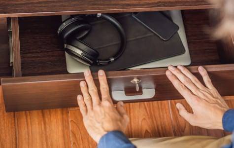 A man puts gadgets in a cabinet for digital detox.